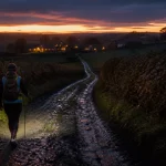 Randonnée nocturne Normandie 2025 : randonneuse au faisceau de lampe frontale
