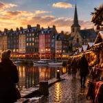 Village de noël à visiter en normandie : marché de Noël d’Honfleur, chalets enneigés au golden hour