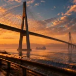 Visiter le pont de Normandie : vue golden hour depuis la rive, estuaire brumeux